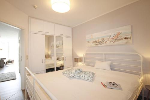 キュールングスボルンにあるHaus-Meeresblick-WE-1-09-zentral-und-strandnah-9979のベッドルーム1室(白い大型ベッド1台付)