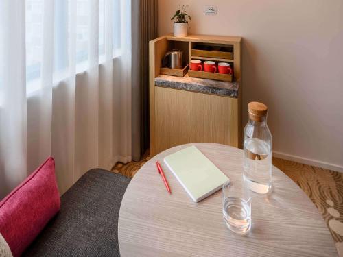 a bottle of water sitting on a table with a book at ibis Melbourne Central in Melbourne