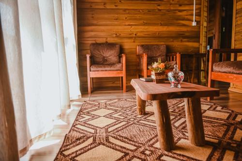 a living room with a table and two chairs at Pousada Recanto dos Canyons in Praia Grande