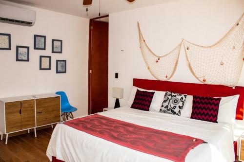 1 dormitorio con 1 cama grande y cabecero rojo en Hermosos Días Soleados en Villa LUNA DEL MAR, en Telchac Puerto