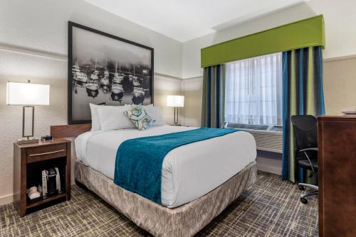 a hotel room with a bed and a desk and a window at The Freeport Hotel, Ascend Hotel Collection in Freeport