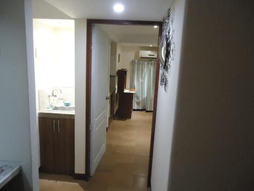 a hallway leading to a kitchen with a sink at SUITES Minimalistas in Guayaquil