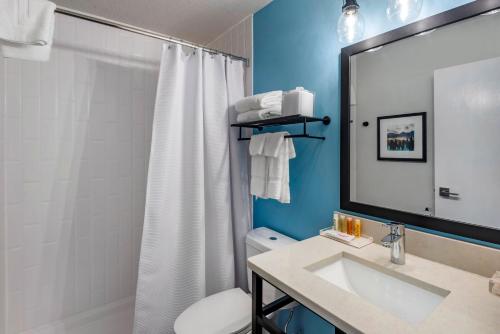 a bathroom with a sink and a toilet and a shower at The Freeport Hotel, Ascend Hotel Collection in Freeport