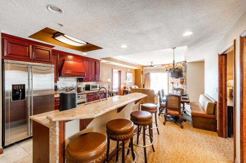 a kitchen with a counter and some bar stools at Condos at Canyons Resort by White Pines in Park City