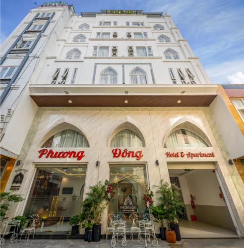 a building with tables and chairs in front of it at Phuong Dong Hotel and Apartment in Quy Nhon