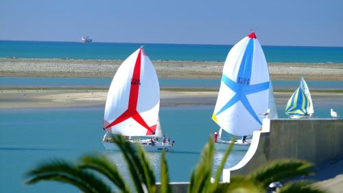 three boats are on the water near the beach at Kimberley One - Nelson Waterfront Apartment in Nelson