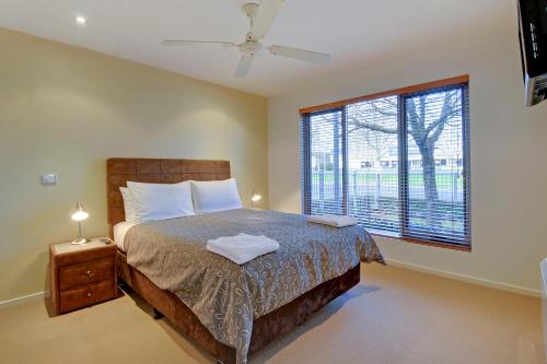 トララルゴンにあるTraralgon Serviced Apartmentsのベッドと大きな窓のある寝室