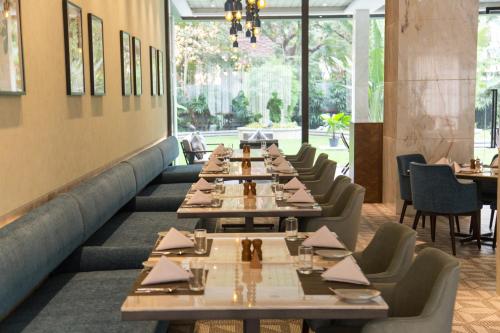 a row of tables and chairs in a restaurant at Radisson Blu Mumbai International Airport in Mumbai