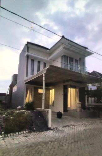 Cette grande maison blanche dispose d'un balcon. dans l'établissement VILLA BAGUS KAYANA H2 DI BATU JAWA TIMUR, à Batu