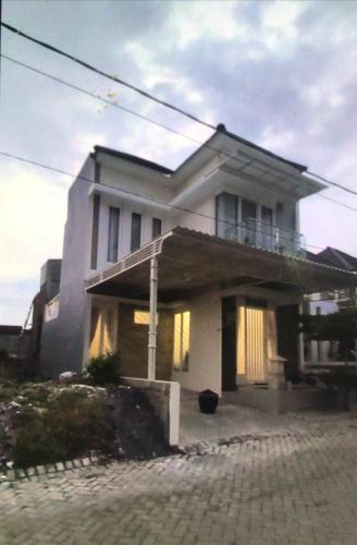 a large white house with a balcony on top of it at VILLA BAGUS KAYANA H2 DI BATU JAWA TIMUR in Batu