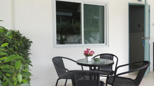 une table et des chaises sur une terrasse avec une fenêtre dans l'établissement Bluemoon Studio Room, à Ko Samet