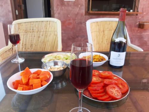 a table with a glass of wine and a plate of fruit at Corsican Haveli in Jodhpur