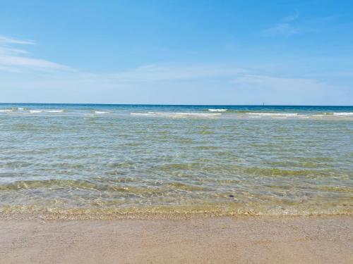 a beach with a body of water with waves at Ferienwohnung Syltliebe in Wenningstedt