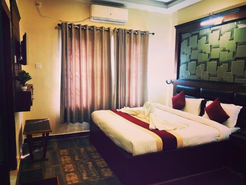 a bedroom with a bed and a window with curtains at Hotel the Narayani in Maruwā Ghāt