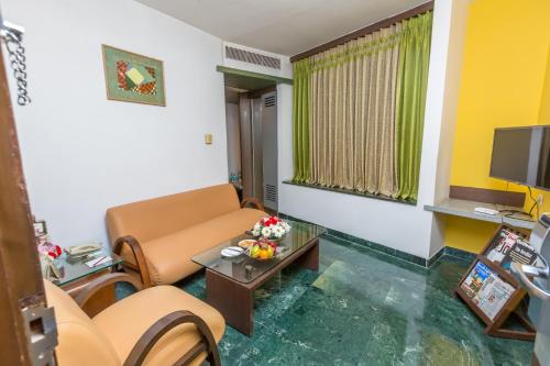 a living room with a couch and a table at Capitol Hill in Rānchī