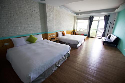 鵝鑾鼻（ガランビ）にある荷風民宿のベッド2台とソファが備わるホテルルームです。
