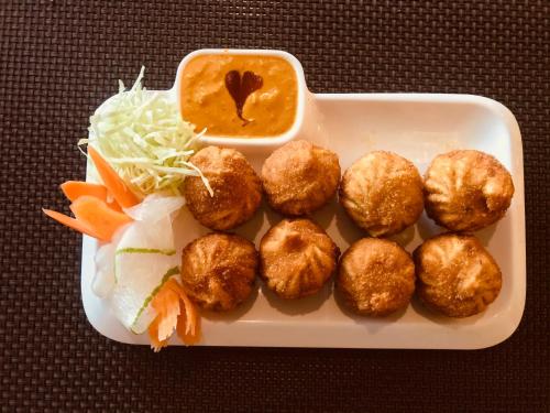 a tray of food with meatballs and carrots and sauce at Hotel the Narayani in Maruwā Ghāt