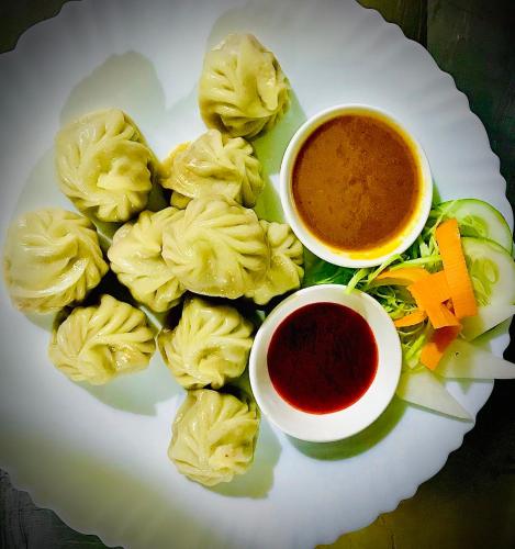 a plate of food with a bowl of dipping sauce at Hotel the Narayani in Maruwā Ghāt