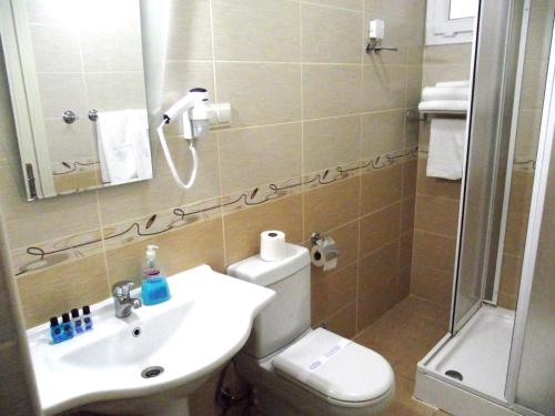 a bathroom with a toilet and a sink and a shower at Alize Resort Hotel in Yenifoça