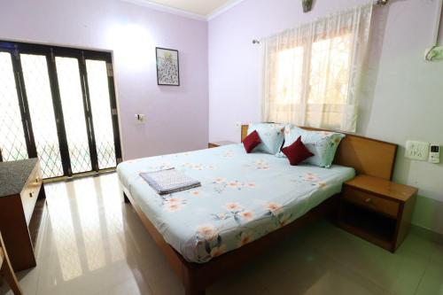 a bedroom with a bed with a laptop on it at Mama Mids Home in Morjim