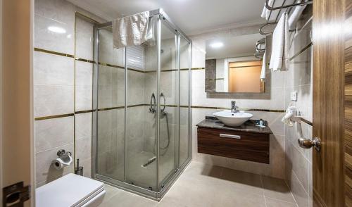 een badkamer met een douche, een toilet en een wastafel bij Madi otel in Konak