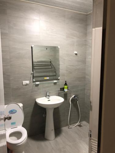 bagno con lavandino, servizi igienici e specchio di Bao Chi B&B a Fanlu