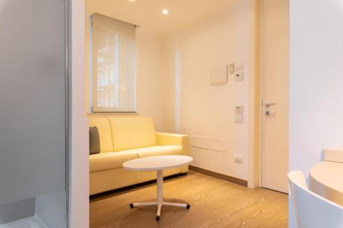 a living room with a yellow couch and a table at Life Hotel Seaview & Spa in Porto Recanati