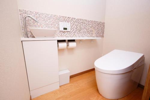 a bathroom with a white toilet and a sink at 肖舎 Shoya in Nara