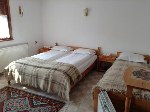 1 dormitorio con 2 camas, mesa y sidx sidx sidx de mesa en Vanda Guest House, en Arbanasi