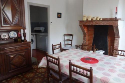 een eetkamer met een tafel en een open haard bij Virevent in Carcassonne