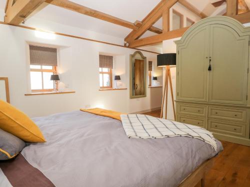 a bedroom with a large bed and a green cabinet at The Cow House in Penrith