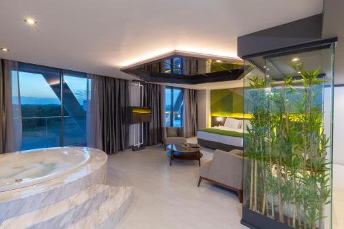 Habitación de hotel con bañera y dormitorio en Bosphorus Sorgun Hotel, en Side