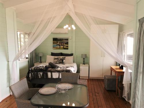 una camera da letto con un letto e un tavolo in una stanza di Kruger View Tree House a Marloth Park