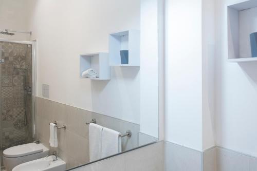 a bathroom with a toilet and a mirror at ZIBIBBO SUITES & ROOMS - Aparthotel in Centro Storico a Trapani in Trapani