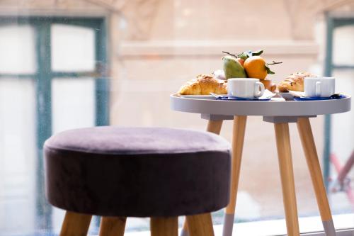 a table with a tray of food and coffee cups at ZIBIBBO SUITES & ROOMS - Aparthotel in Centro Storico a Trapani in Trapani