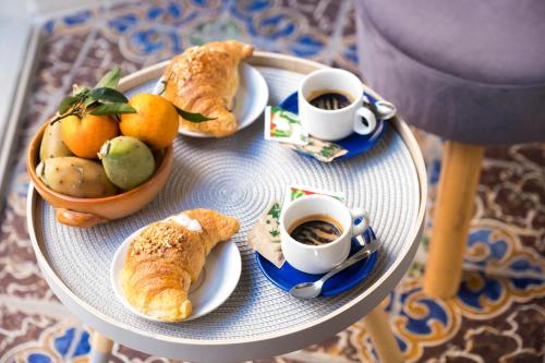 a tray of food with cups of coffee and croissants at ZIBIBBO SUITES & ROOMS - Aparthotel in Centro Storico a Trapani in Trapani