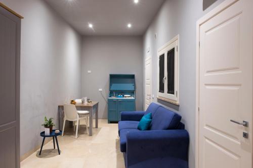 a living room with a blue couch and a table at ZIBIBBO SUITES & ROOMS - Aparthotel in Centro Storico a Trapani in Trapani