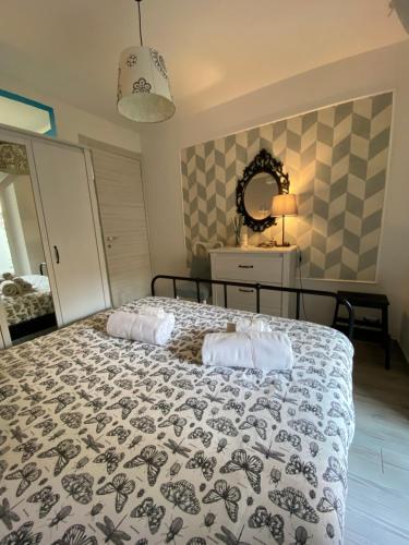 a bedroom with a bed with a comforter on it at La CasAffittiera Apartments Group in Anzio