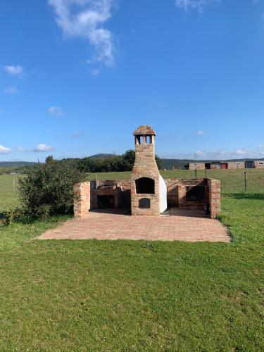 a brick oven in the middle of a field at Öregtölgy Apartman in Szár