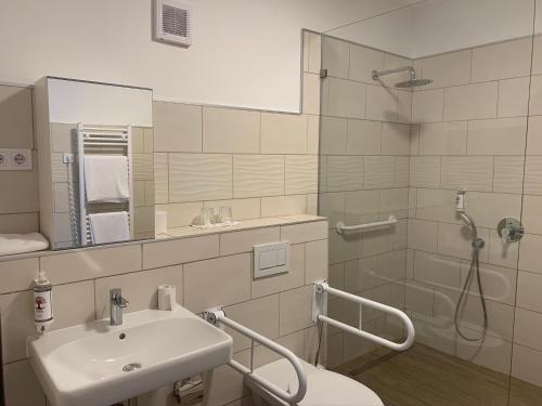 a bathroom with a sink and a shower at Öregtölgy Apartman in Szár