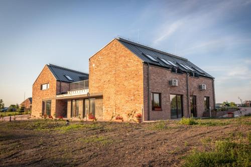 a brick house with solar panels on top of it at Öregtölgy Apartman in Szár