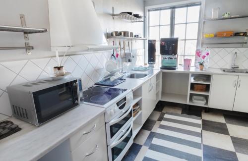 une cuisine avec des placards blancs et une télévision sur un comptoir dans l'établissement Motala Wärdshus, à Motala