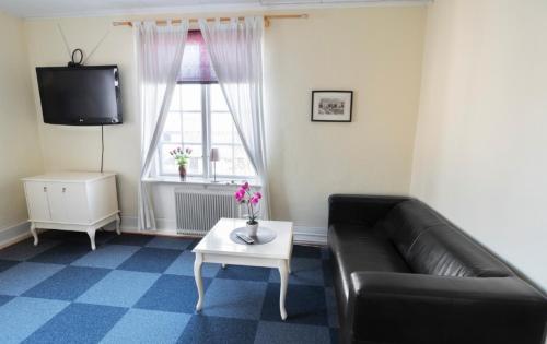 a living room with a couch and a coffee table at Motala Wärdshus in Motala