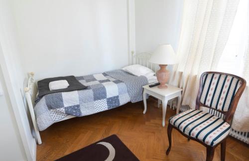 a bedroom with a bed and a chair and a lamp at Motala Wärdshus in Motala