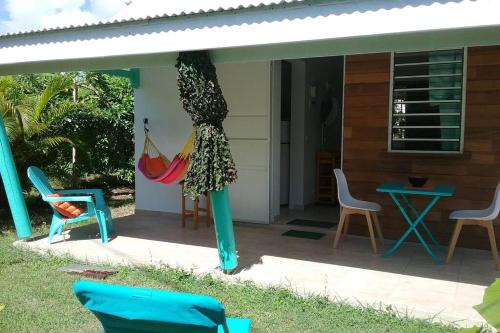 a porch with chairs and a hammock on it at Gîte Cajou Sainte-Anne, Confort & proximité in Sainte-Anne