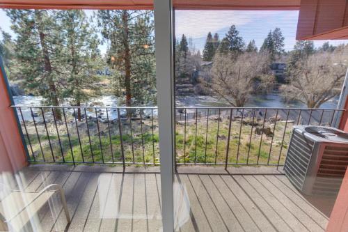 a balcony with a view of a river at Bend Riverside Condos Near Downtown Bend in Bend