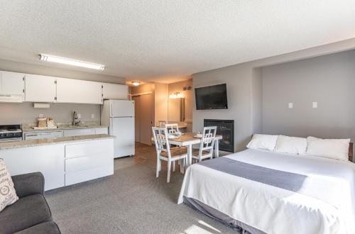 a bedroom with a bed and a kitchen with a table at Bend Riverside Condos Near Downtown Bend in Bend