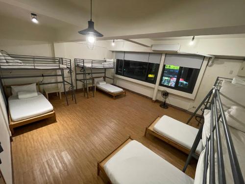 Chiayi Petite Hostel في مدينة تشيايي: غرفة بها ثلاثة أسرة بطابقين وشرفة