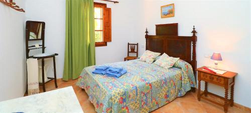 een slaapkamer met een bed en een tafel met een lamp bij 414 Finca Can Crestall VT1725 by Mallorca Charme in Campos