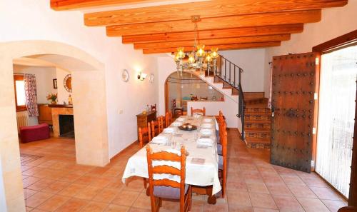 een eetkamer met een lange tafel en een trap bij Finca Can Palea 407 by Mallorca Charme in Campos